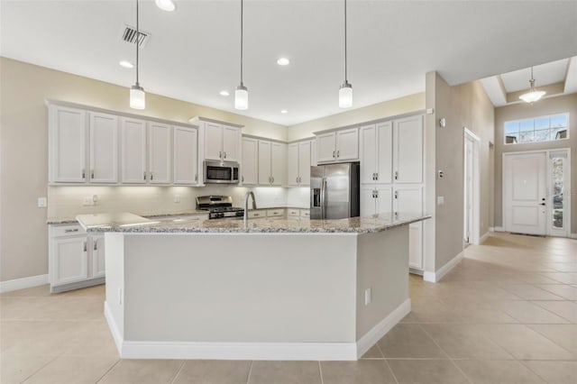 kitchen featuring visible vents, an island with sink, light stone countertops, stainless steel appliances, and pendant lighting