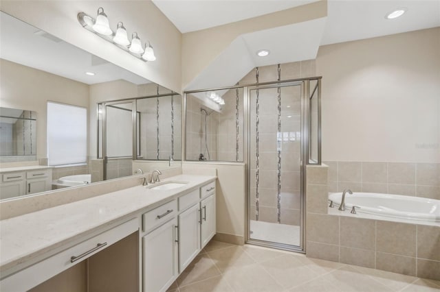 full bath featuring a stall shower, tile patterned flooring, a garden tub, and vanity