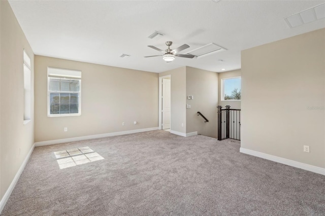 empty room with visible vents, light carpet, and baseboards