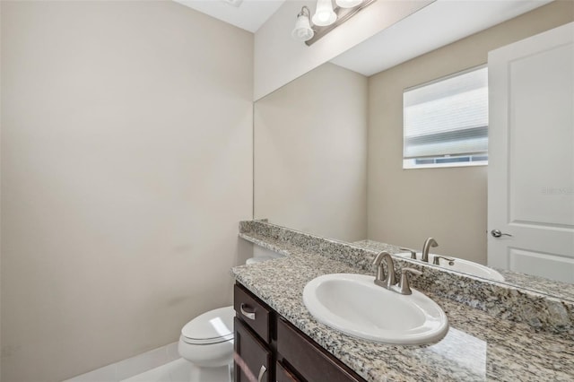 bathroom featuring toilet, vanity, and baseboards