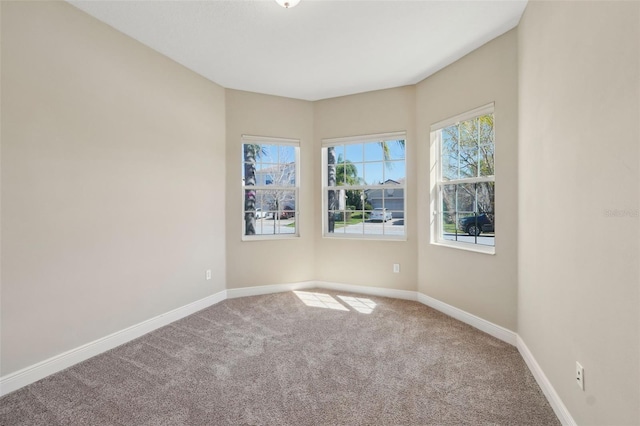 carpeted spare room with baseboards