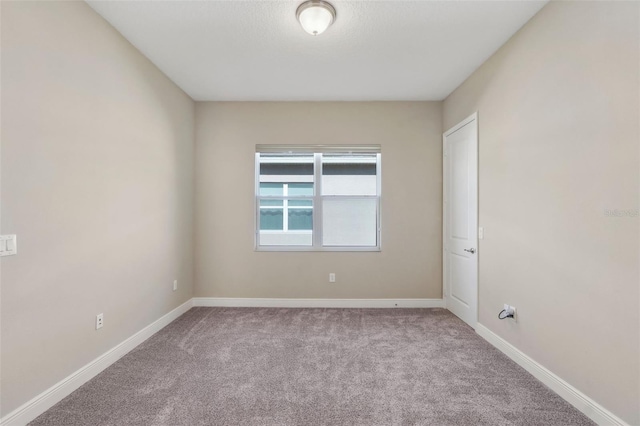 carpeted empty room with baseboards