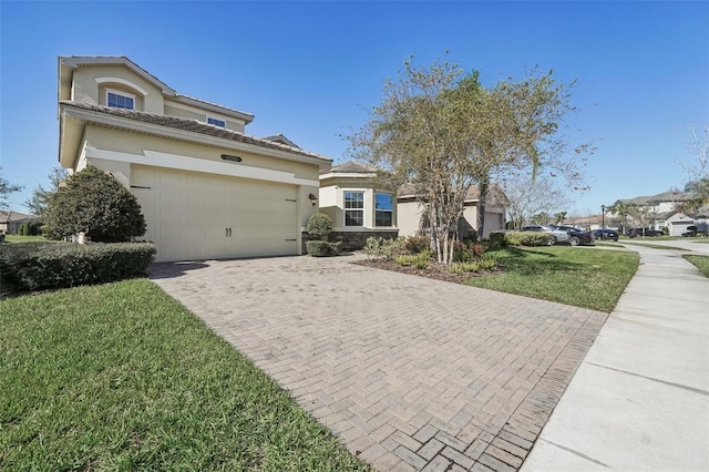 view of front facade featuring decorative driveway, stucco siding, a garage, stone siding, and a front lawn