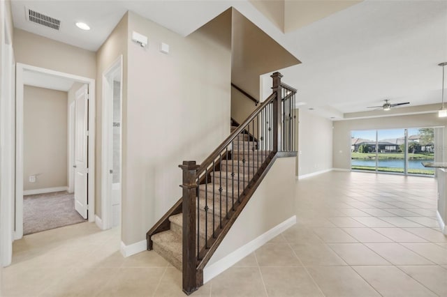 stairs with baseboards, tile patterned flooring, visible vents, and a ceiling fan