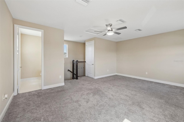 unfurnished room with carpet floors, visible vents, and a ceiling fan