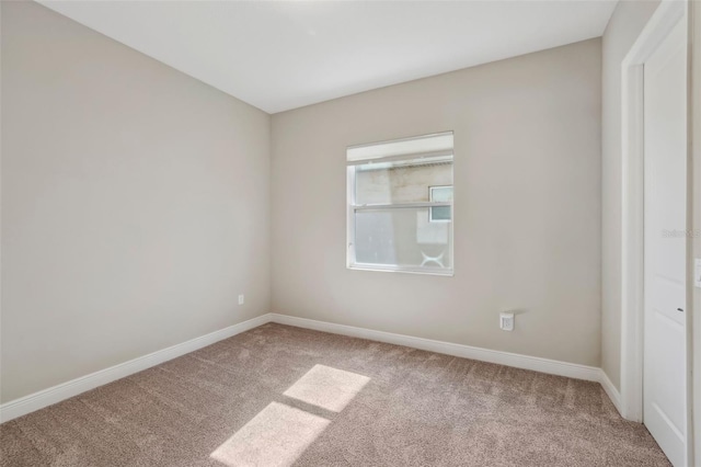 unfurnished room featuring carpet and baseboards