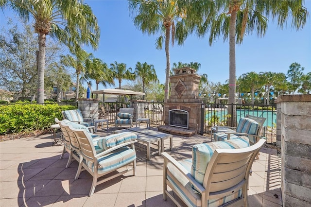 view of patio featuring fence and an outdoor living space with a fireplace