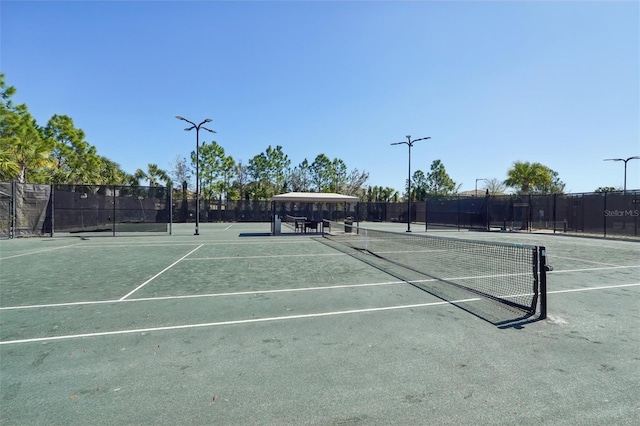 view of tennis court featuring fence