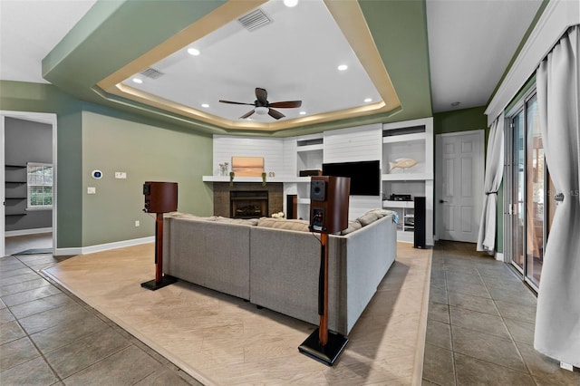 living room with visible vents, a raised ceiling, recessed lighting, a fireplace, and baseboards