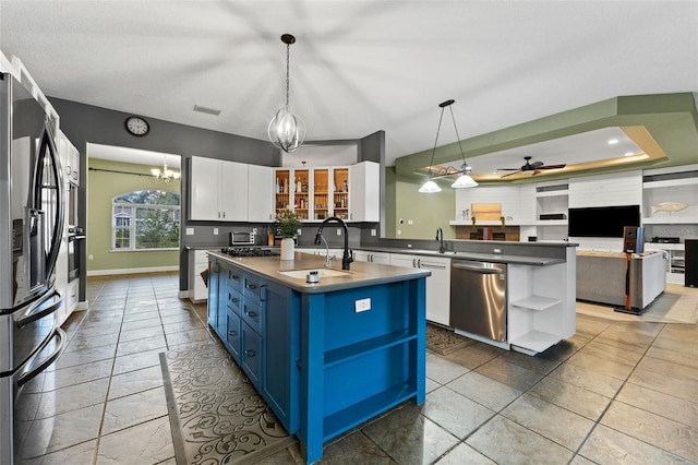 kitchen with open shelves, a sink, white cabinets, blue cabinets, and refrigerator with ice dispenser