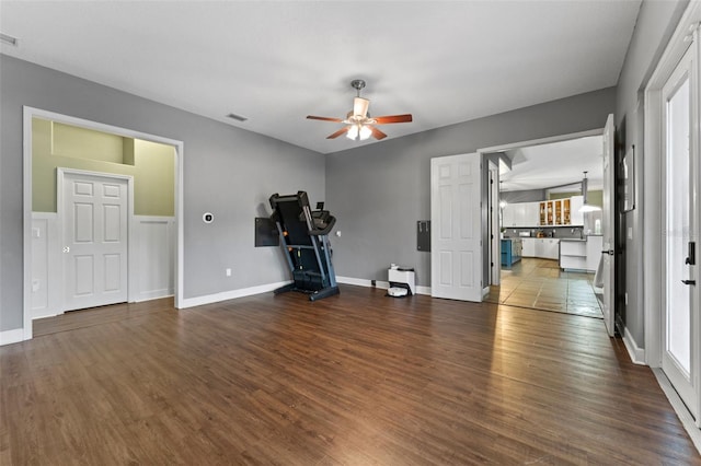 workout area with a ceiling fan, wood finished floors, visible vents, and baseboards