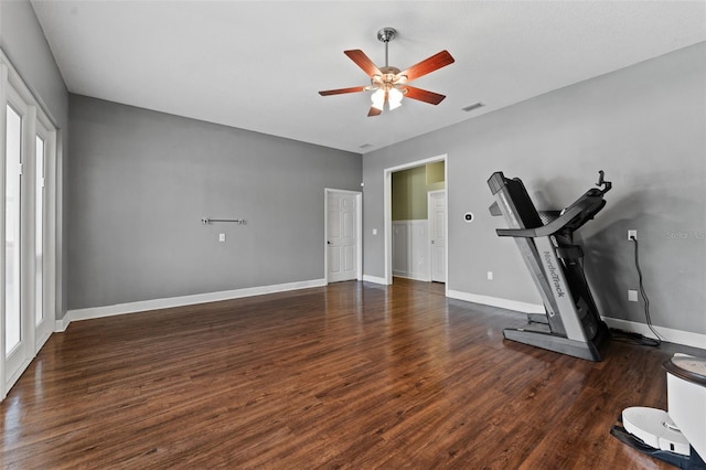 workout area with ceiling fan, visible vents, baseboards, and wood finished floors