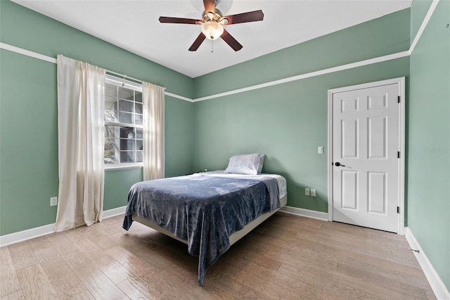 bedroom with ceiling fan, baseboards, and wood finished floors