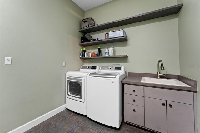 laundry room with washing machine and clothes dryer, cabinet space, baseboards, and a sink