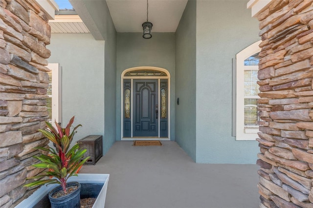 view of exterior entry featuring stucco siding