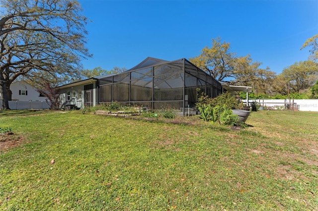 view of yard with a lanai and fence