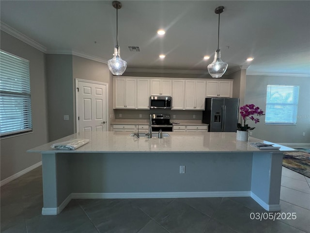 kitchen with a sink, white cabinets, appliances with stainless steel finishes, a large island with sink, and crown molding