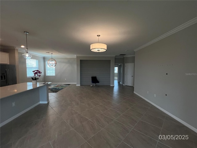 unfurnished living room with baseboards, dark tile patterned floors, and crown molding