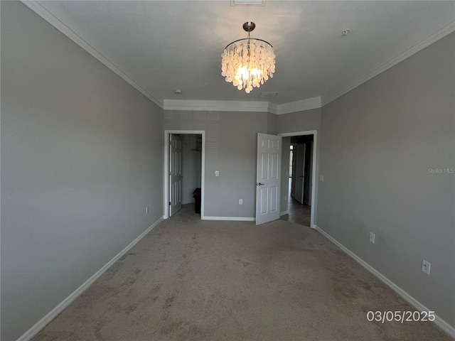 unfurnished bedroom featuring a chandelier, baseboards, a spacious closet, ornamental molding, and carpet