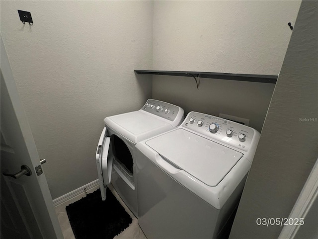 washroom with washer and dryer, laundry area, a textured wall, and baseboards