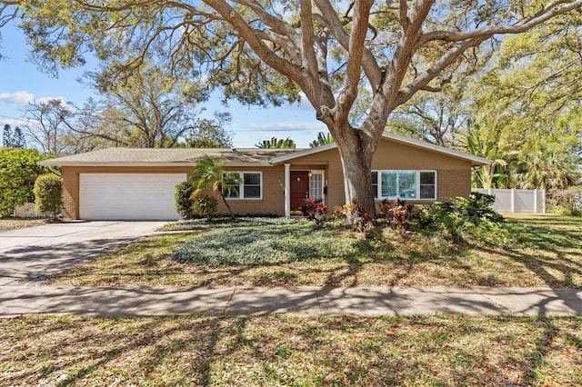 ranch-style home with brick siding, fence, and an attached garage