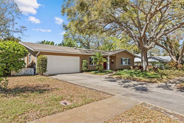 ranch-style house with a garage, concrete driveway, and stucco siding