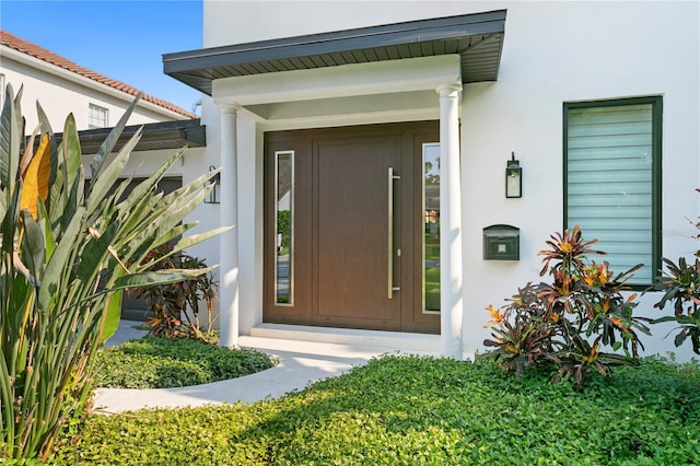 doorway to property featuring stucco siding