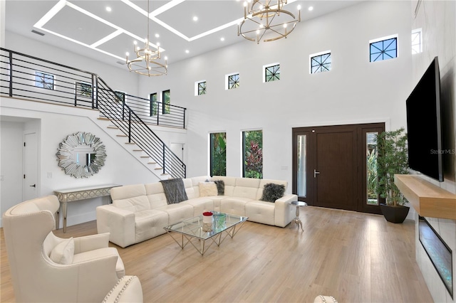 living area with a chandelier, stairway, recessed lighting, a towering ceiling, and wood finished floors