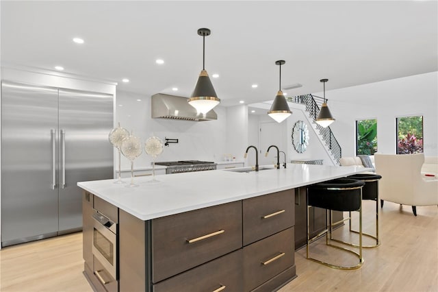 kitchen featuring dark brown cabinetry, light wood-style flooring, light countertops, and stainless steel appliances