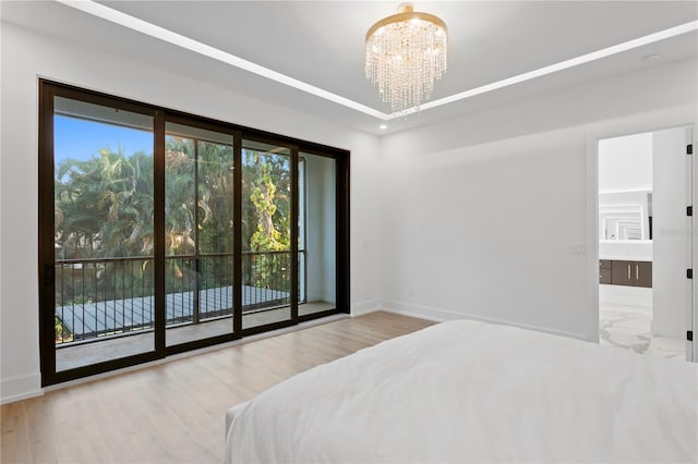 bedroom with wood finished floors, baseboards, and a chandelier