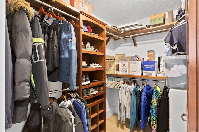 walk in closet with wood finished floors