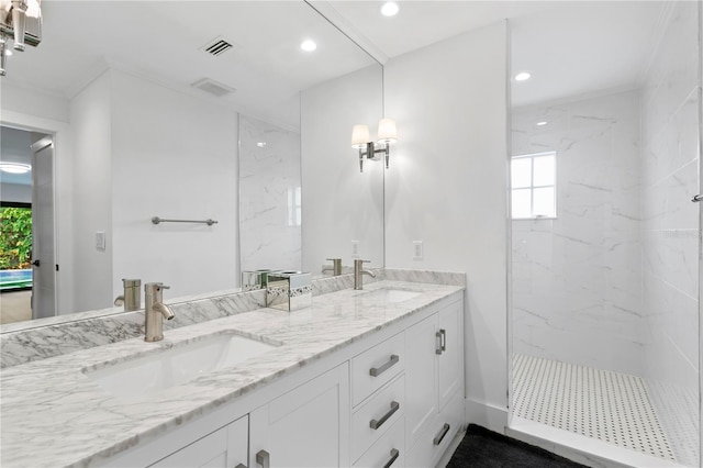 bathroom with double vanity, visible vents, a marble finish shower, and a sink