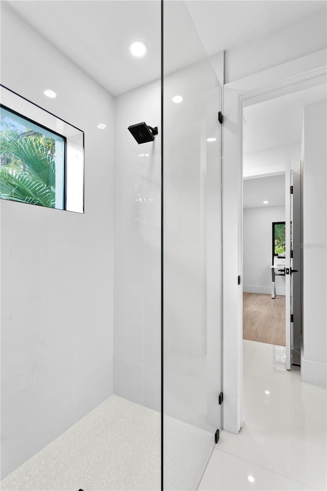 bathroom with a tile shower and a healthy amount of sunlight