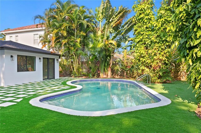 view of swimming pool featuring a patio, a lawn, a fenced in pool, and fence private yard