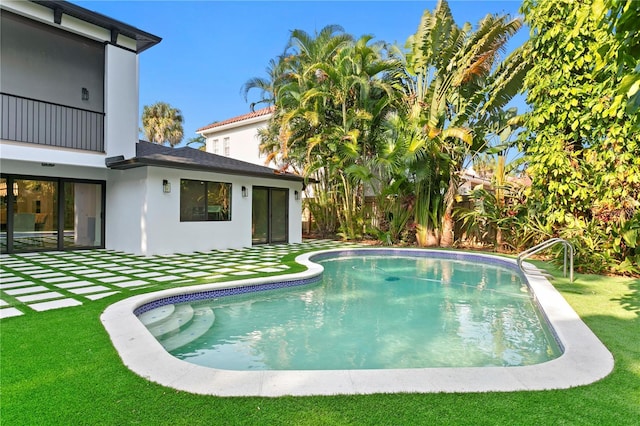 view of pool featuring a patio and a lawn