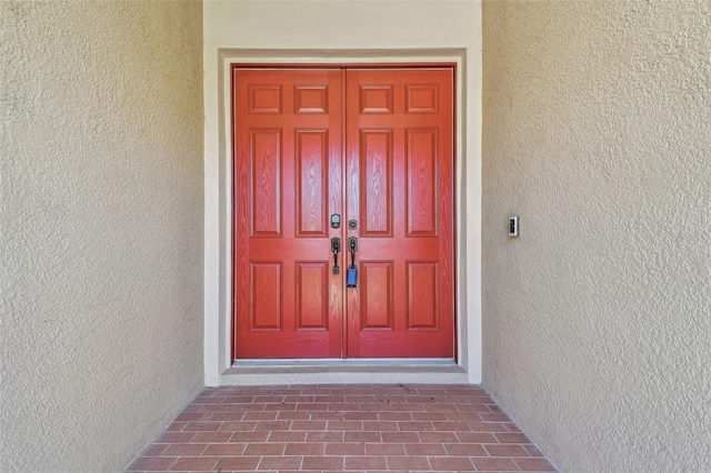 view of exterior entry with stucco siding