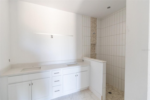 bathroom with a sink, marble finish floor, and walk in shower