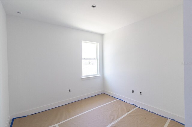 unfurnished room with baseboards