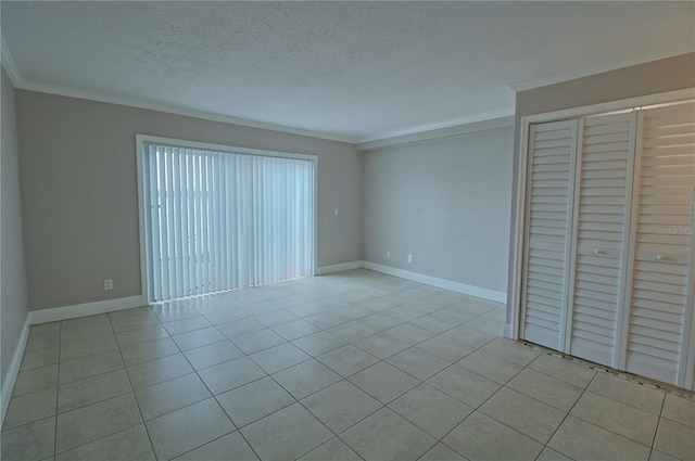 unfurnished bedroom with a closet, a textured ceiling, crown molding, and light tile patterned flooring