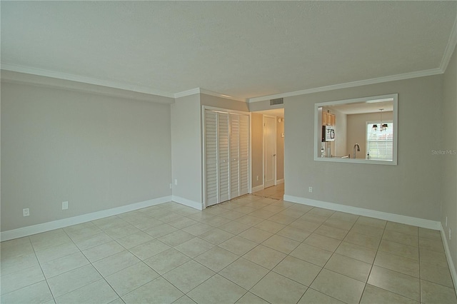 spare room with baseboards, visible vents, ornamental molding, and a sink