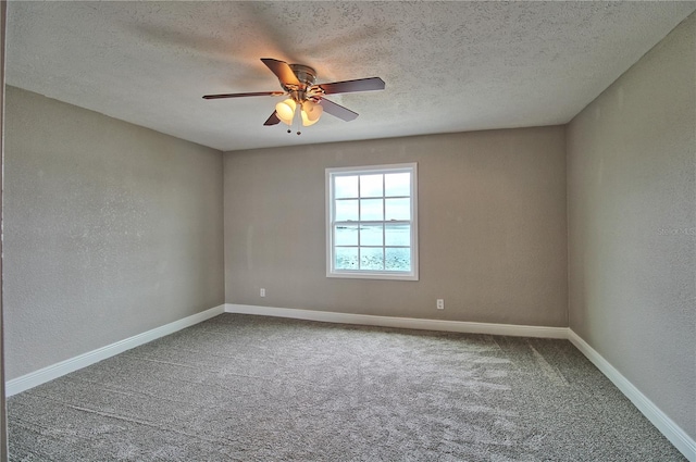 spare room featuring carpet, a textured wall, a ceiling fan, a textured ceiling, and baseboards