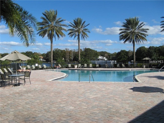 community pool featuring a patio and fence