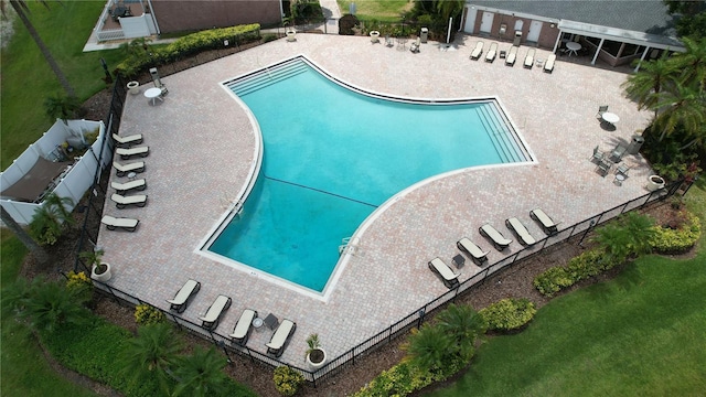 pool with a patio area and fence