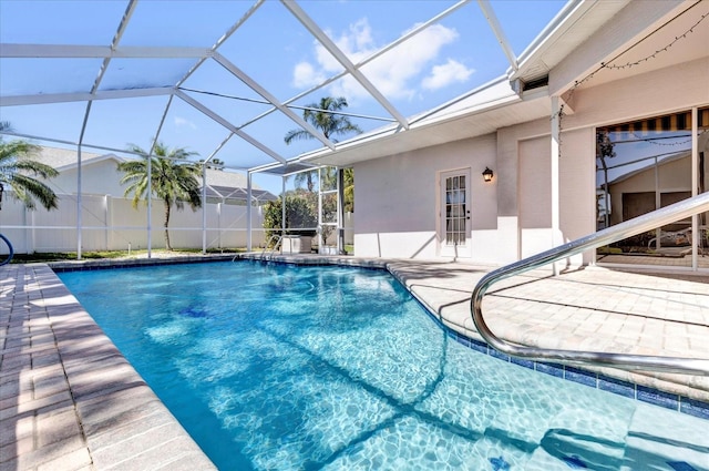 view of pool featuring a lanai, fence, a fenced in pool, and a patio