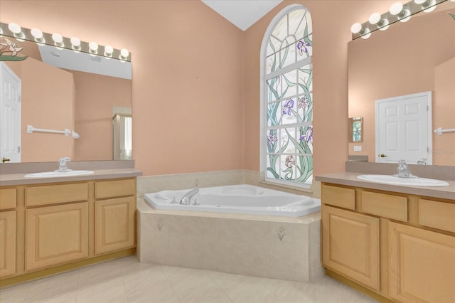 bathroom with a bath, two vanities, and a sink