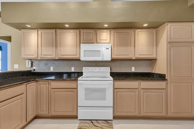 kitchen with light brown cabinetry, white appliances, dark stone countertops, and tasteful backsplash