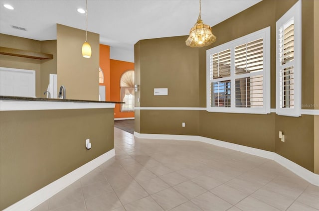 empty room featuring recessed lighting, baseboards, a sink, and tile patterned floors