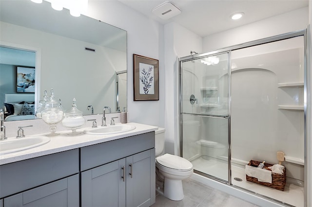 ensuite bathroom featuring toilet, a shower stall, double vanity, and a sink