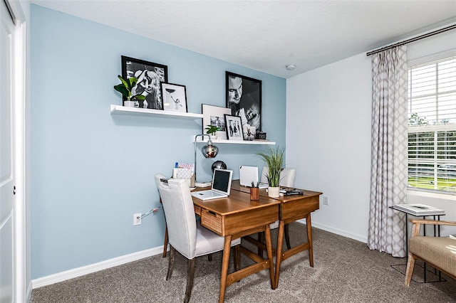 carpeted home office featuring baseboards and a textured ceiling