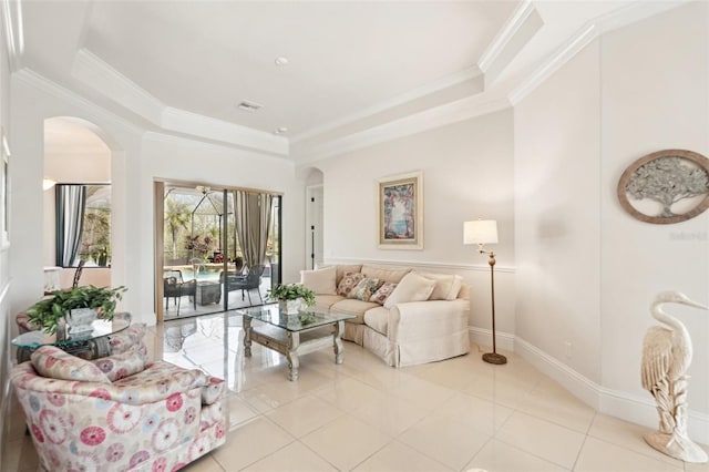 living room with arched walkways, a tray ceiling, and ornamental molding